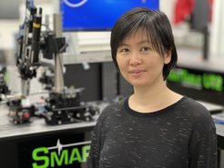 Prof. Joyce Poon is standing in front of a 2D photonen laser